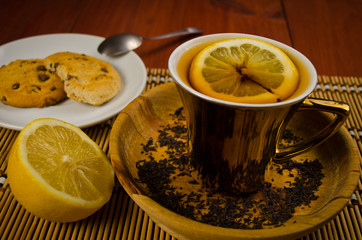 tea with lemon and coockies on wooden table