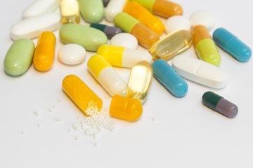 Many colored pills / tablets / capsules on white background