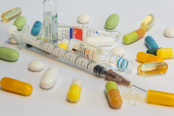 Medicine, many pills and syringe with needle