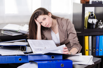 Business woman with so many paperwork in the office