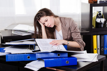 Business woman with so many paperwork in the office