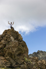Ragazzo con braccia in alto in montagna