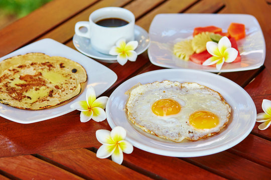 Breakfast with eggs, pineapple pancake and fruits