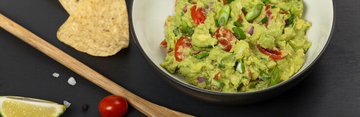 Guacamole on black background. Selective focus.