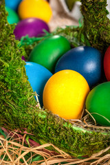 Fototapeta na wymiar Colored Easter eggs in a wooden basket