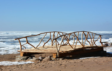 Wooden bridge on the frozen sea shore