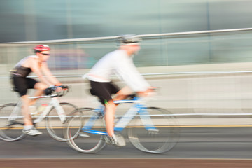 Two Athlets riding bicycle in the city, blurred motion.