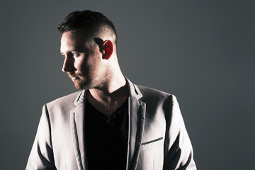 Man posing with dark background and hard lighting