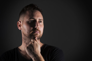 Man posing with dark background and hard lighting