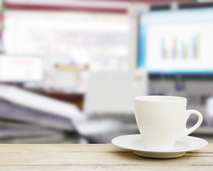 coffee in the cup on old wood table with blur office background