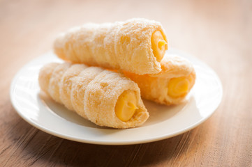 Cream-filled pastry roll on the wood board