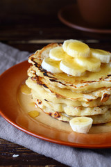 Sweet pancakes with honey and bananas on a plate