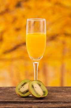 glass of juice with kiwi slices on a wooden table