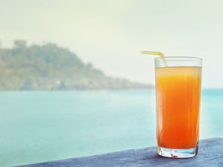 glass of orange juice on the background of the sea background
