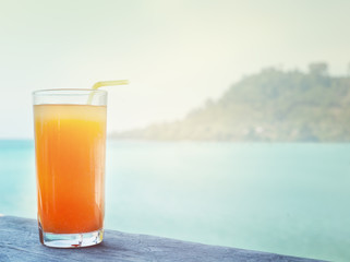 glass of orange juice on the background of the sea background