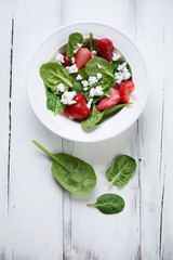 Salad with strawberries, spinach and cheese, studio shot