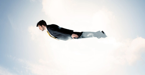 Business man flying like a superhero in clouds on the sky