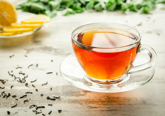 Glass cup of tea on a wooden table.