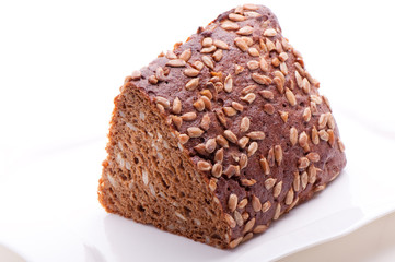Brown bread with sunwlower seeds on a white plate