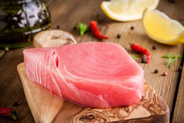 Raw tuna fillet with lemon and olive oil - obrazy, fototapety, plakaty