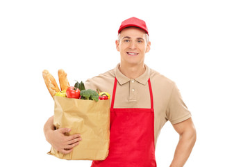 Young market vendor holding a bag full of groceries