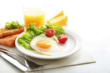 Bacon and eggs on color wooden table background