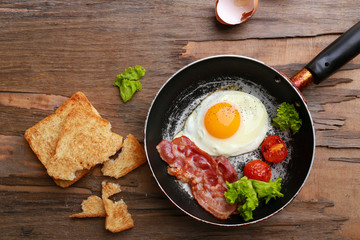 Bacon and eggs on rustic wooden planks background