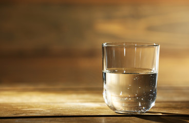 Glass of clean mineral water on rustic wooden background