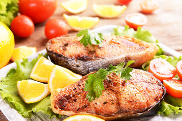 Tasty baked fish on plate on table close-up