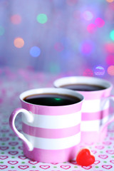Two cups on table on lights background