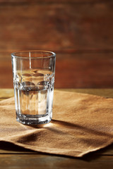 Glass of water on table on wooden background