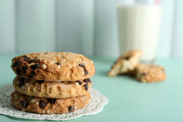 Tasty cookies and glass of milk on color wooden background