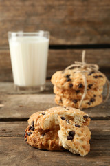 Tasty cookies and glass of milk on rustic wooden background