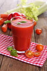 Glass of tomato juice with vegetables on wooden table close up