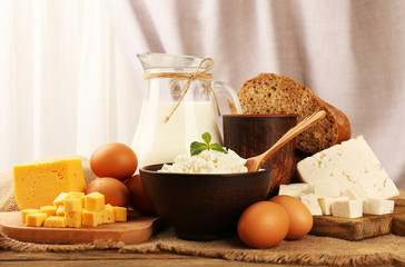Tasty dairy products with bread on table on fabric background