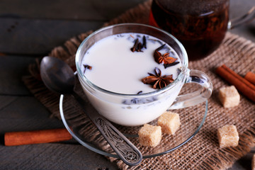 Black tea with milk in glassware and lump sugar