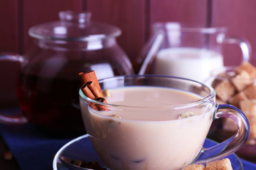 Black tea with milk and lump sugar and spices  in glassware