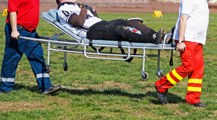 Medics take care of the injured football player - obrazy, fototapety, plakaty