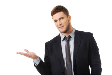 Handsome businessman holding copyspace on palm.