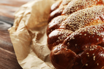 Fresh bun on paper on wooden background