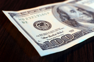 Hundred dollar banknote on wooden table background