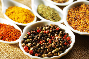 Different kinds of spices in ceramics spoons, close-up,