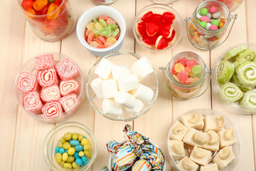 Sweetness in different containers on wooden background