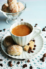 Cup of coffee and tasty cookie on color wooden background