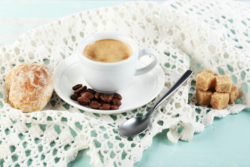 Cup of coffee and tasty cookie on color wooden background