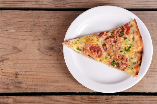 Tasty Slice Of Pizza On Plate On Wooden Table