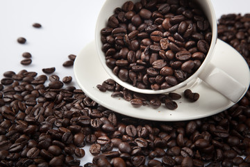 Roasted coffee beans with a cup