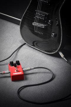 Guitar conneted to red overdrive effect pedal