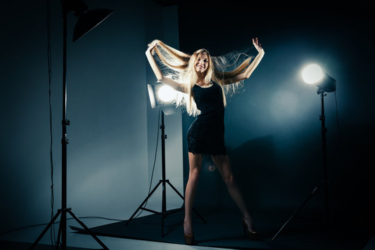 Beautiful woman posing at studio in light flashes