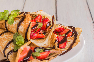 Homemade Crepes with strawberries and chocolate syrup